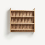 Shelve unit in oak wood. Three shelves. Woven wood back. Shaker peg rail at bottom with black metal pegs.