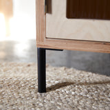 Bottom corner of birch ply wood cabinet showing reeded glazed door and slim black metal let.