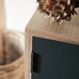 Close up of ply wood cabinet showing joint detail and dark grey painted door with traditional hinge.