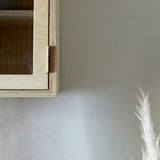 Bottom corner of ply wood wall cabinet with reeded glazed door and hinge.
