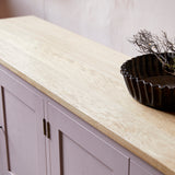 Pink painted shaker sideboard with oak worktop and large vintage metal tart tin on top.