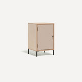 Single door ply wood contemporary bedside cabinet with pink painted door, black metal door knobs and black metal legs. Shown at an angle.
