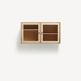 Two door ply wood contemporary wall cupboard with reeded glass doors and black metal door knobs.