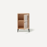 Single door ply wood contemporary bedside cabinet with reeded glass door open to right revealing internal shelf, black metal door knobs and black metal legs.