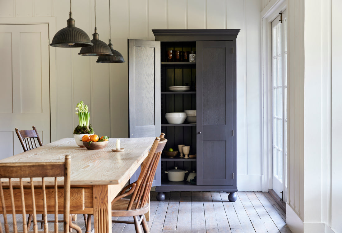 Dining room with wooden table, chairs, and a dark brown cabinet.