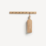 Oak Shaker peg rail with seven black metal knobs and a chopping board hanging