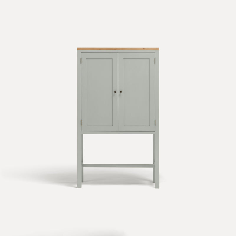 White painted two door shaker style cabinet on tall legs with oak work top. 