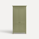 Green painted freestanding tall Armoire cupboard Shaker style with panelled doors and black metal knobs. Shown face on with both doors closed.