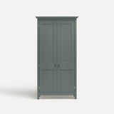Blue painted freestanding tall Armoire cupboard Shaker style with panelled doors and black metal knobs. Shown face on with both doors closed.