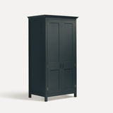 Dark Blue Grey painted freestanding tall Armoire cupboard Shaker style with panelled doors and black metal knobs. Shown at angle with both doors closed.
