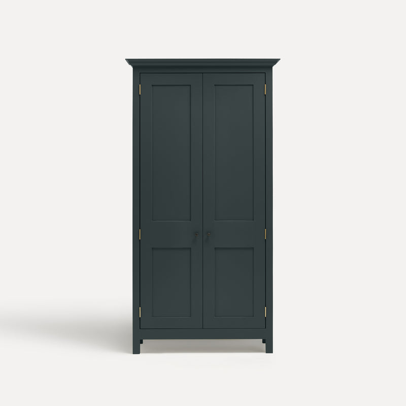 Dark Blue Grey painted freestanding tall Armoire cupboard Shaker style with panelled doors and black metal knobs. Shown face on with both doors closed.