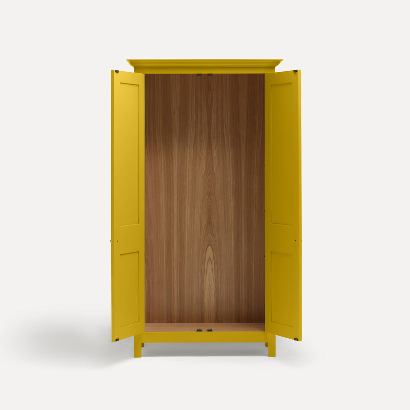 Yellow painted freestanding tall Armoire cupboard Shaker style with panelled doors and black metal knobs. Shown face on with both doors open.