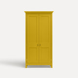 Yellow painted freestanding tall Armoire cupboard Shaker style with panelled doors and black metal knobs. Shown face on with both door closed.