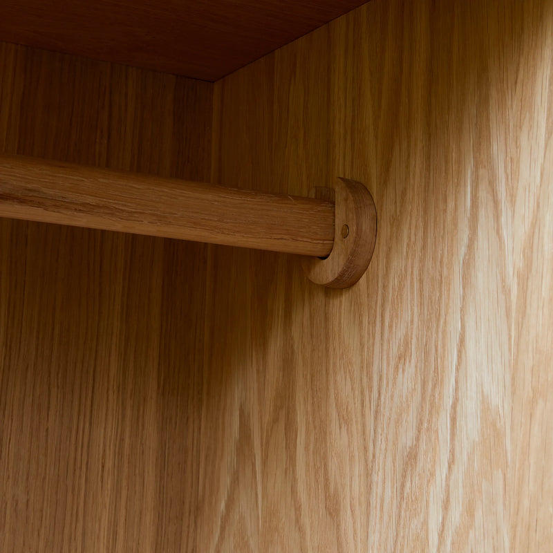 Internal shot showing oak clothes rail and oak cupboard interior.