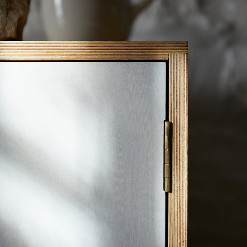 Top corner of cabinet with white painted door, hinge and ply wood joint detail.