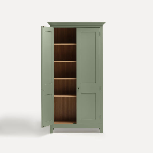 Green painted freestanding tall cupboard Shaker style with panelled doors black metal knobs. One door open revealing oak interior and four shelves.