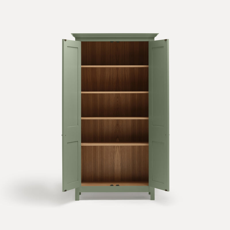 Green painted freestanding tall cupboard Shaker style with panelled doors black metal knobs. Both doors open revealing oak interior and four shelves.