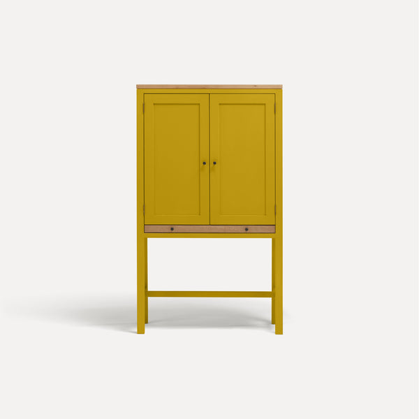 Yellow painted two door shaker style cabinet on tall legs with oak work top. 