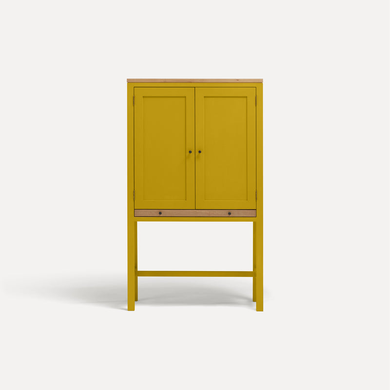 Yellow painted two door shaker style cabinet on tall legs with oak work top. 