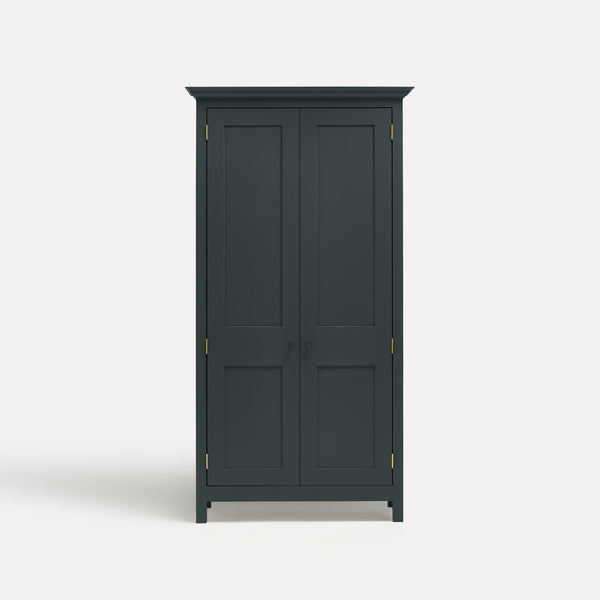 Dark grey blue painted freestanding tall cupboard Shaker style with panelled doors black metal knobs.